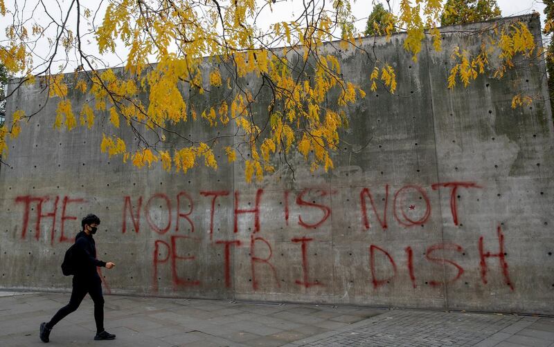 A man walks past graffiti on a wall in Manchester. Reuters