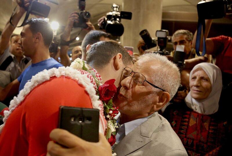 Ahmed Abughaush hugs his father. Raad Adayleh / AP Photo