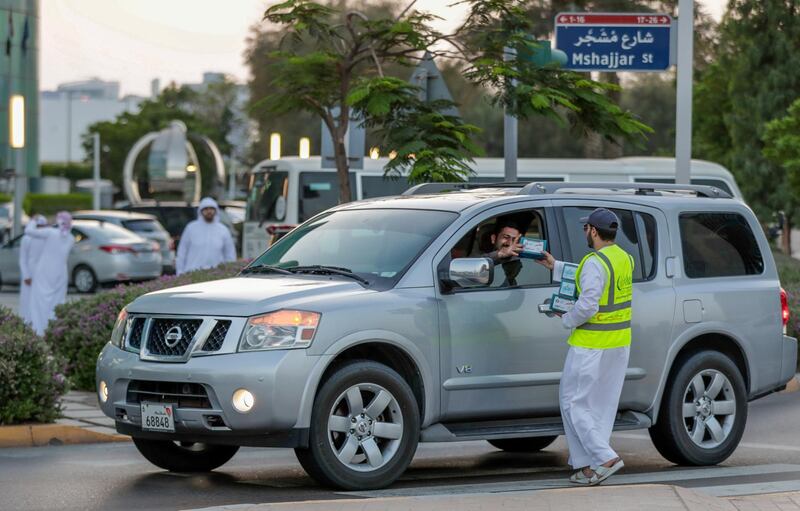 Abu Dhabi, United Arab Emirates, May 7, 2019.    Red Crescent volunteers and Abu Dhabi Police distribute food to motorists during iftar at the corner of 11th St. and 18th Sports City area.
Victor Besa/The National
Section:  NA
Reporter:  Haneen Dajani