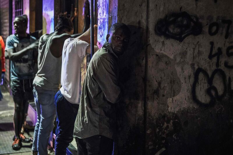 Suspects are lined up against a wall while they are being arrested by the South African Police Service (SAPS) because they defied the lockdown order during an operation in the Johannesburg CBD.  AFP