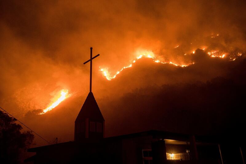 Flames from a wildfire advance down a hillside near the Springs of Life Church in Casitas Springs, California. Noah Berger / AP Photo