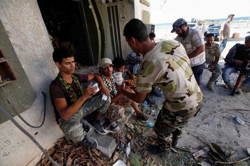 Fighters from Libyan forces allied with the UN-backed Government of National Accord receive meals during a battle with ISIL fighters in Sirte's District 1 neighbourhood on August 17, 2016. Ismail Zitouny/Reuters