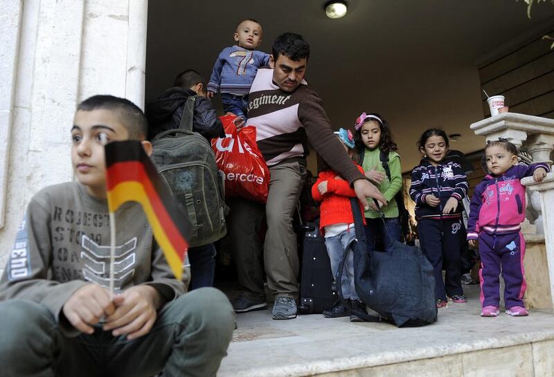 Syrian refugees family wait at the entrance of the International Organization for Migration (IOM) headquarters in Beirut, Lebanon. Wael Hamzeh / EPA