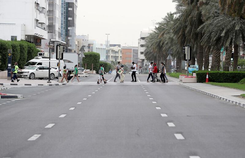 DUBAI, UNITED ARAB EMIRATES , April 11 – 2020 :- Pedestrian crossing the road without any traffic on the Al Muraqqabat road in Deira Dubai. Dubai is conducting 24 hours sterilisation programme across all areas and communities in the Emirate and told residents to stay at home. UAE government told residents to wear face mask and gloves all the times outside the home whether they are showing symptoms of Covid-19 or not. (Pawan Singh/The National) For News/Online/Instagram/Standalone