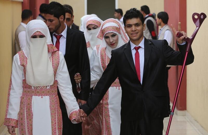 Palestinian bride Marwa Mousa and her groom Ahmed Abu Salama take part in the mass wedding ceremony in Gaza City. Mahmud Hams / AFP