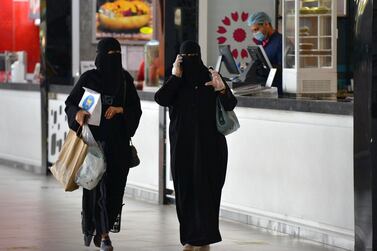 Women carry shopping bags and food they picked up from a restaurant in a mall in the Saudi capital Riyadh on June 4, 2020, after it reopened following the easing of some restrictions put in place by the authorities in a bid to stem the spead of the novel coronavirus. (Photo by FAYEZ NURELDINE / AFP)