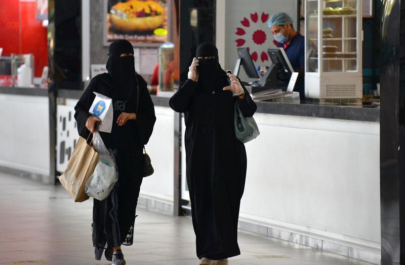 Women carry shopping bags and food they picked up from a restaurant in a mall in the Saudi capital Riyadh on June 4, 2020, after it reopened following the easing of some restrictions put in place by the authorities in a bid to stem the spead of the novel coronavirus. (Photo by FAYEZ NURELDINE / AFP)