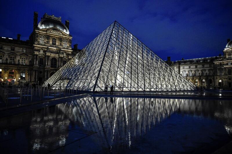 This photograph taken on October 29, 2020 in Paris shows an exterior view of the Musee du Louvre at its closing time and the Pyramide du Louvre, designed by Ieoh Ming Pei, ahead of a second national general lockdown from October 30 to December 1, aimed at curbing the spread of Covid-19. - France and Germany have moved toward shutting down sectors of their economies as part of accelerating efforts worldwide to check a resurgent coronavirus and still limit the financial fallout. (Photo by STEPHANE DE SAKUTIN / AFP) / RESTRICTED TO EDITORIAL USE - MANDATORY MENTION OF THE ARTIST UPON PUBLICATION - TO ILLUSTRATE THE EVENT AS SPECIFIED IN THE CAPTION