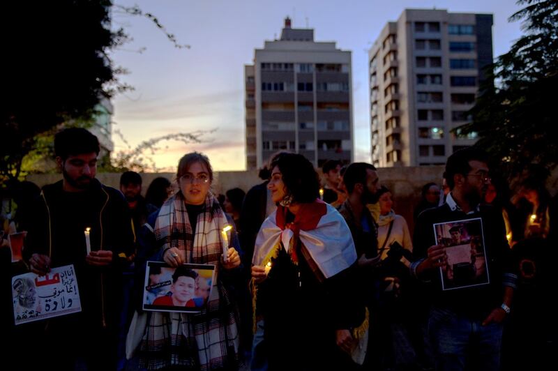 Lebanese activists hold candles during a protest to support children taking part in the uprising in front of the Iraqi embassy in Beirut.  EPA