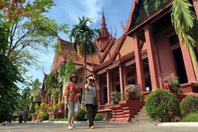 Tourists walk past the National Museum building in Phnom Penh on May 10, 2013. Cambodia is expected to receive 4 million foreign visitors in 2013, an expected 12 percent rise year-on-year. AFP PHOTO/ TANG CHHIN SOTHY / AFP PHOTO / TANG CHHIN SOTHY