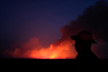 A man is seen on a burning tract of the Amazon jungle in Canarana, Brazil. Reuters