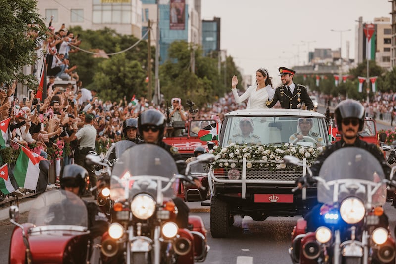 Prince Hussein and Princess Rajwa wave to Jordanians on the streets of Amman after their wedding. Reuters
