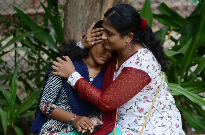 Kriti Bharti embraces Santa Devi Meghwal, a victim of child marriage, now 20. AFP