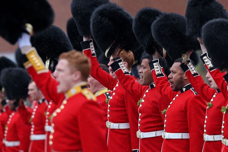 Members of the 1st Battalion Irish Guards raise their bearskin hats to salute their new colonel, the Princess of Wales. AFP