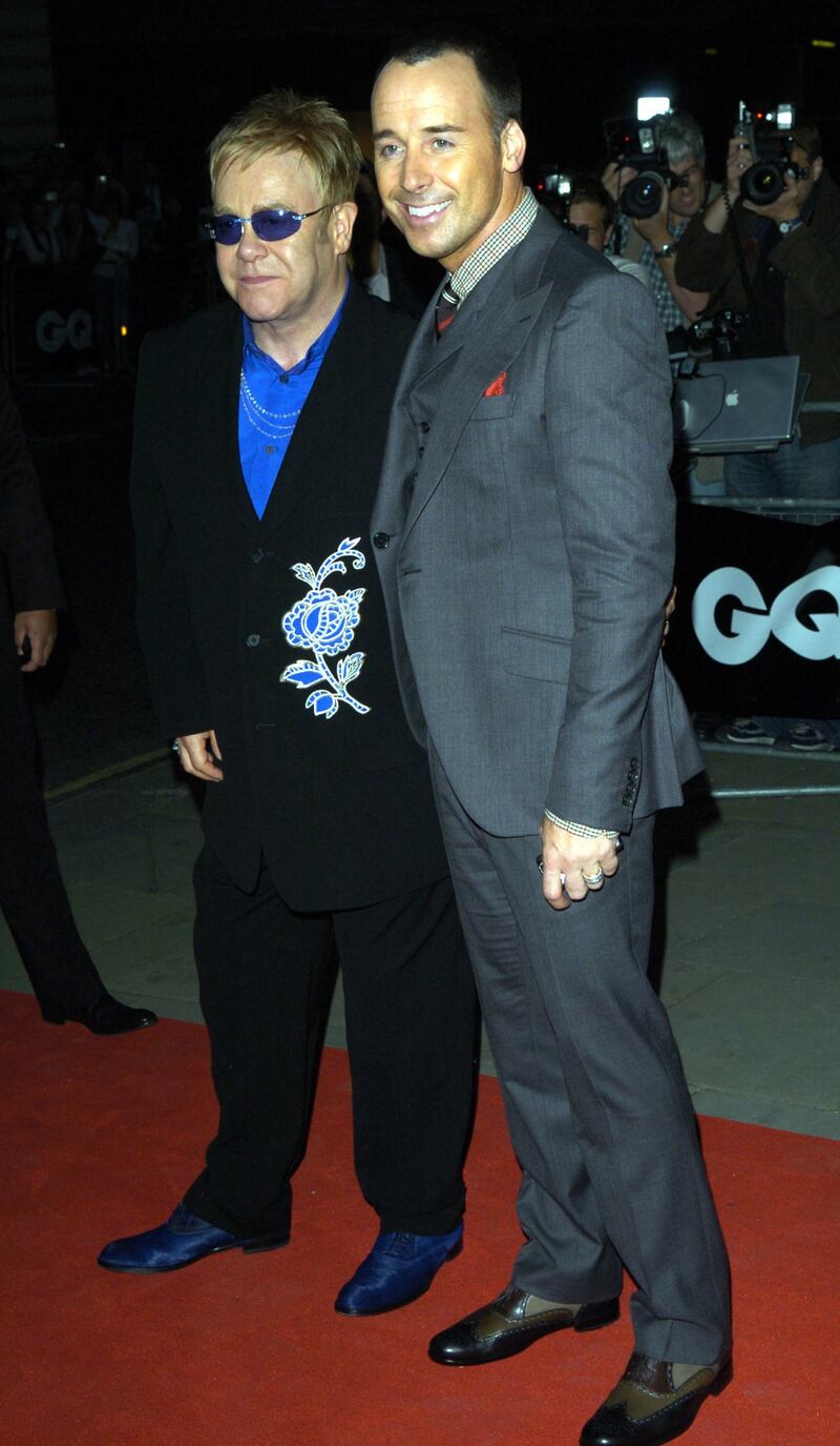 Elton John, in a black suit with a blue flower detail, and David Furnish attend the GQ Men of the Year Awards at the Royal Opera House, London on September 4, 2007. Getty Images