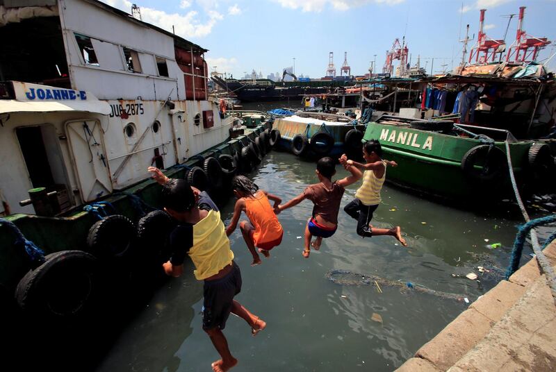 Children jump into the polluted waters of Manila Bay to cool off from the intense heat. Romeo Ranoco / Reuters