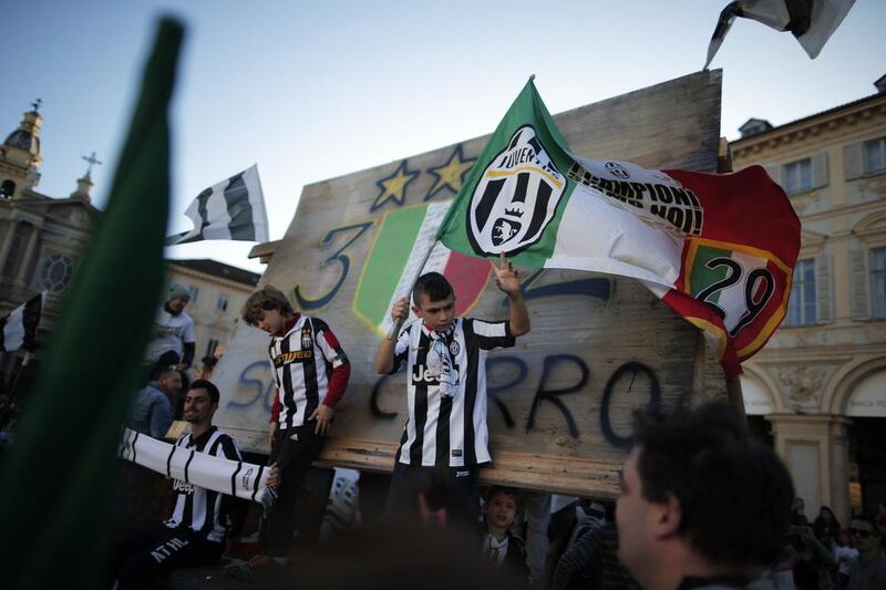 Juventus supporters took to the streets at Piazza San Carlo in Turin on May 4, 2014 after their football club won the Scudetto for the 30th time . MARCO BERTORELLO / AFP

