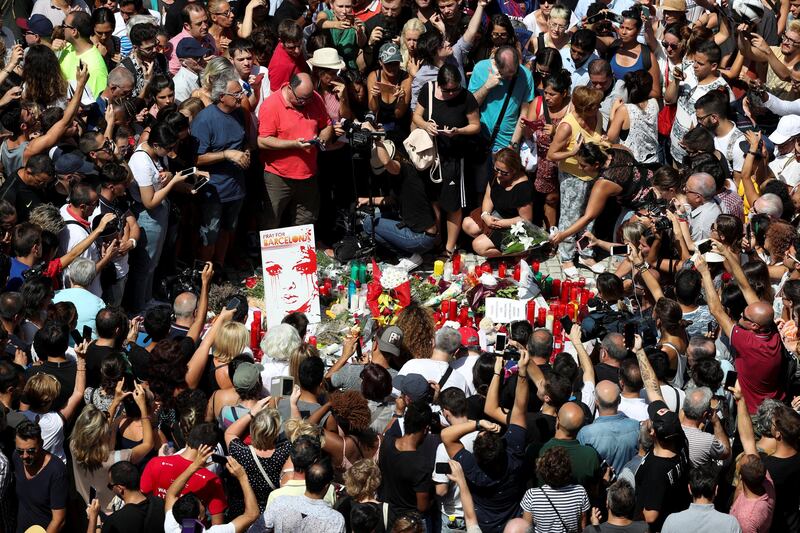 A woman places a bouquet of flowers at Las Ramblas the day after a van crashed into pedestrians in Barcelona, Spain August 18, 2017. REUTERS/Sergio Perez