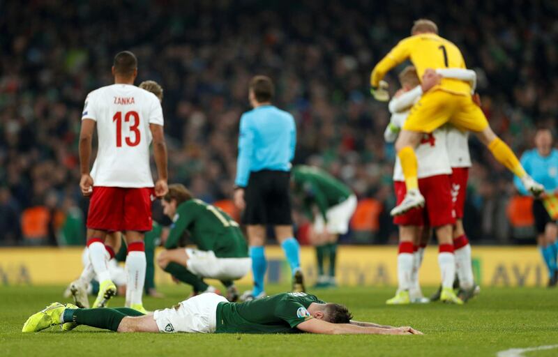 Republic of Ireland players look dejected as Denmark players celebrate at the end of the match. Reuters