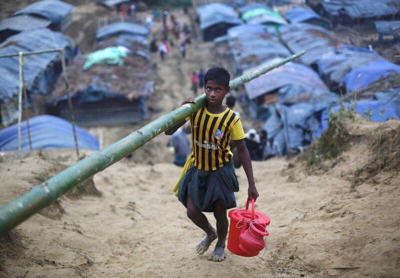 A Rohingya refugee carries bamboo for making a temporary shelter at a camp in Cox's Bazar, Bangladesh September 19, 2017. REUTERS/Danish Siddiqui