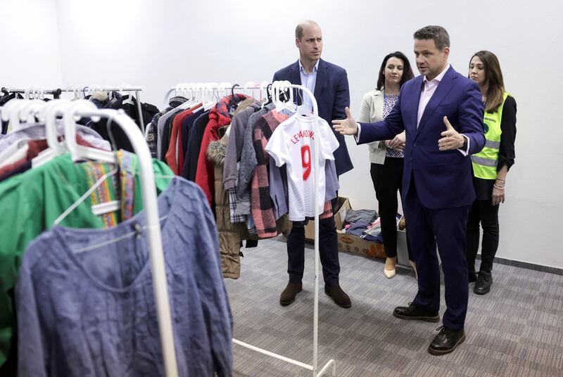 Prince William and Mayor of Warsaw Rafal Trzaskowski view clothes that the centre has received and distributed via a 'free shop'. Reuters
