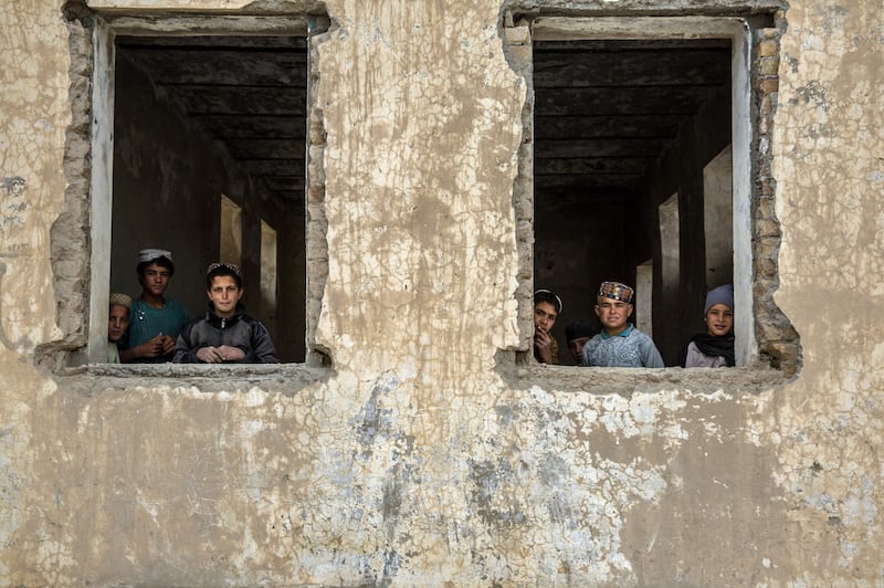 Children peak through a classroom window at Shahid Niamatullah Primary School in Panjwayi district, formerly occupied by ISAF and the Afghan National Police. 