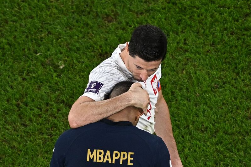 Poland's Robert Lewandowski embraces Mbappe after the 3-1 tie. AFP
