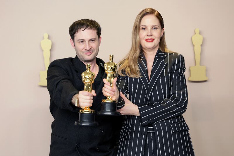 Arthur Harari and Justine Triet hold up Oscars for Best Original Screenplay for Anatomy of a Fall. EPA / Allison Dinner