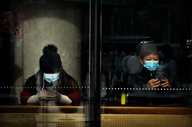 People sit in a coffee shop in Beijing, China. AP Photo