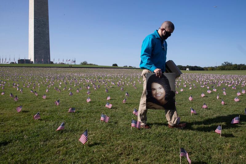 Chris Duncan of Alexandria, Virginia, walks with a picture of his mother Constance Duncan, who died with COVID-19 on her 75th birthday, among thousands of flags placed to memorialize Americans that died with COVID-19; near the base of the Washington Monument on the National Mall in Washington, DC, USA, 22 September 2020. The 'COVID Memorial Project' installed 20,000 flags near the Washington Monument to memorialize the two hundred thousand people in the United States who have died with COVID-19. EPA