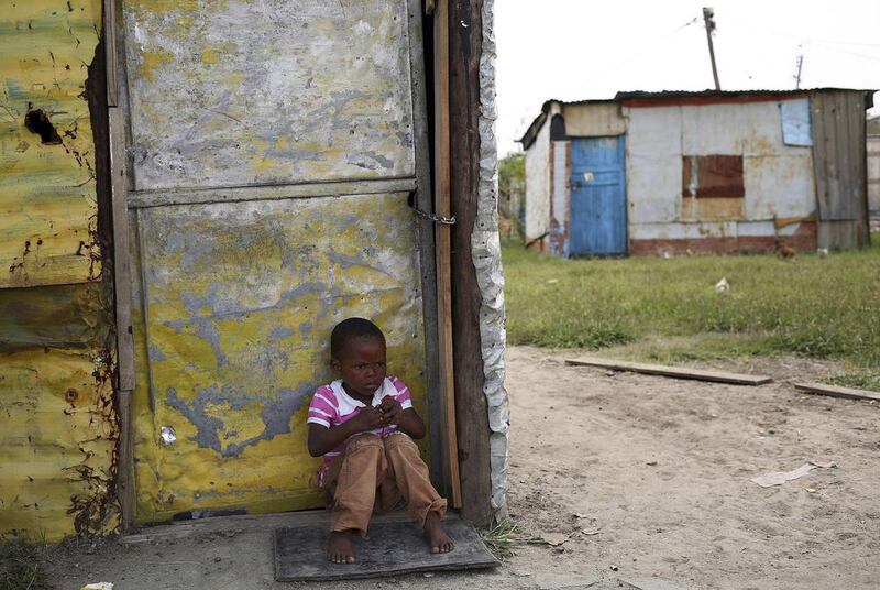 A child sits outside a locked shack in Nkaneng township, Marikana’s informal settlement, in Rustenburg. Union members have downed tools at platinum-producing miners in a strike over wages. Siphiwe Sibeko / Reuters
