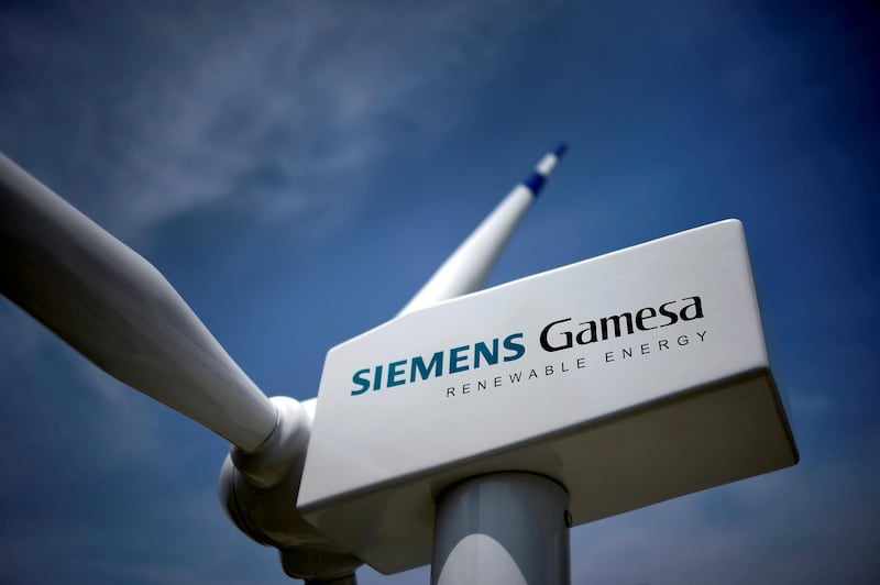 FILE PHOTO: A model of a wind turbine with the Siemens Gamesa logo is displayed outside the annual general shareholders meeting in Zamudio, Spain, June 20, 2017. REUTERS/Vincent West/File Photo