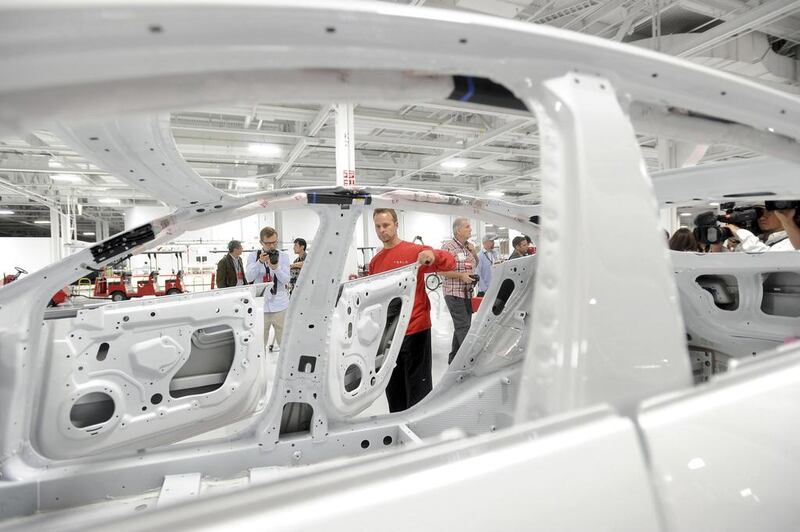 Sales of Tesla’s Model S in China, which begin next month, may match US volume as early as next year. A production supervisor examines a Model S for paint quality at the company’s factory. Noah Berger / Reuters