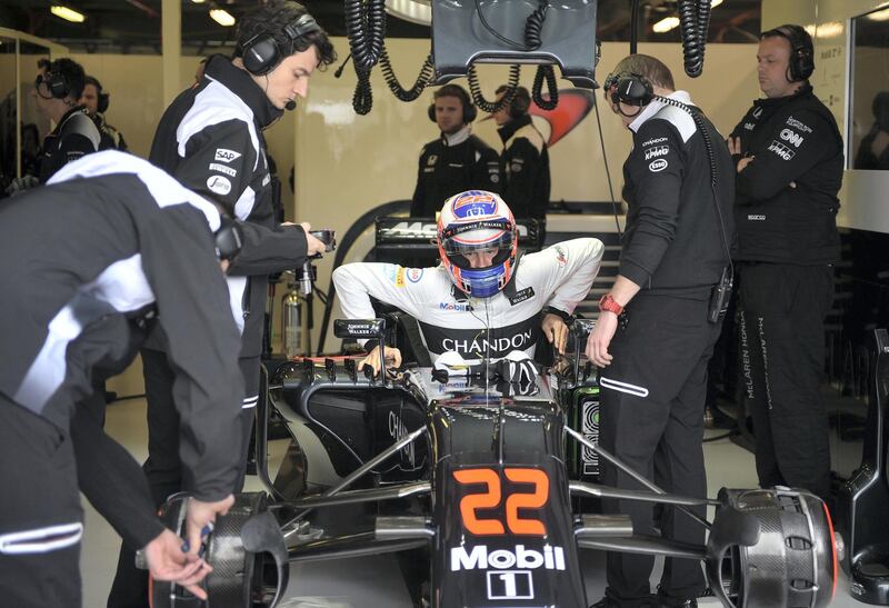 McLaren Honda's British driver Jenson Button (C) gets in his car in the garage during the first practise session of the Formula One Australian Grand Prix in Melbourne on March 18, 2016. (Photo by PETER PARKS / AFP) / --IMAGE RESTRICTED TO EDITORIAL USE - STRICTLY NO COMMERCIAL USE--