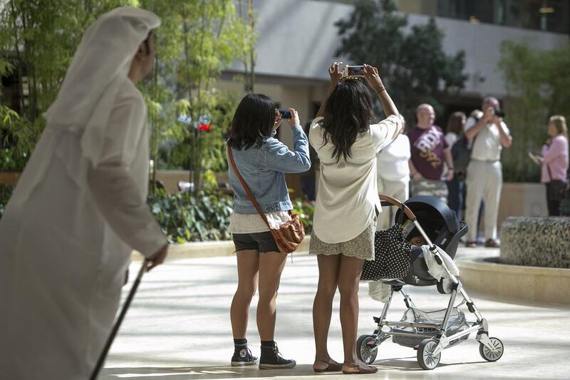 People take photos of the impressive design of Yas Mall. Silvia Razgova / The National