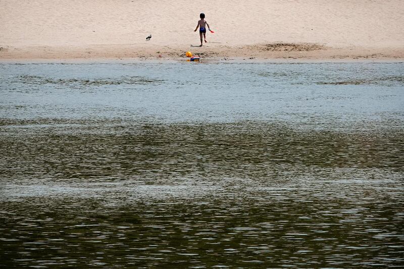 A small child runs on a beach on the banks of the river Danube in Calarasi, southern Romania. AP Photo