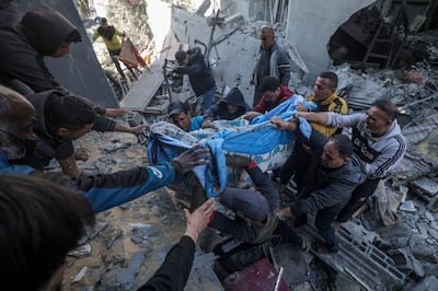 Palestinians recover a body from the rubble of a destroyed house following Israeli air strikes, in Deir Al Balah, central Gaza Strip. EPA
