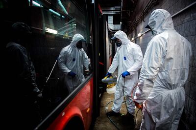 Workers wearing protective clothes disinfect an interior of a public bus in a bus-wash station at Transport Company of Bratislava city as part of precautionary measures against the spread of the new coronavirus COVID-19 in Bratislava, Slovakia on March 11, 2020. Many schools were closed and public events were cancelled due to the coronavirus outbreak in Slovakia as first seven cases of infection were confirmed. / AFP / VLADIMIR SIMICEK
