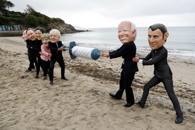 Oxfam activists with 'Big Head' caricatures of G7 leaders, during a protest at a beach near Falmouth. Reuters