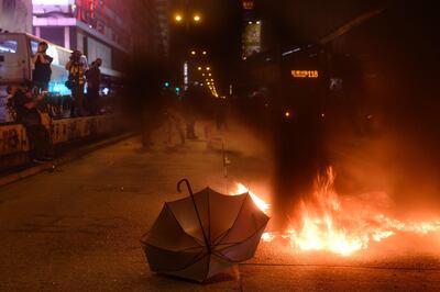 An umbrella is left on the road as protesters burn barricades in Mong Kok district of Hong Kong on November 2, 2019. Hong Kong police fired tear gas and water cannon on November 2 as thousands of protesters hit the streets, defying authorities with another unsanctioned march as the democracy movement shows no signs of abating after nearly five months. 
 / AFP / Philip FONG
