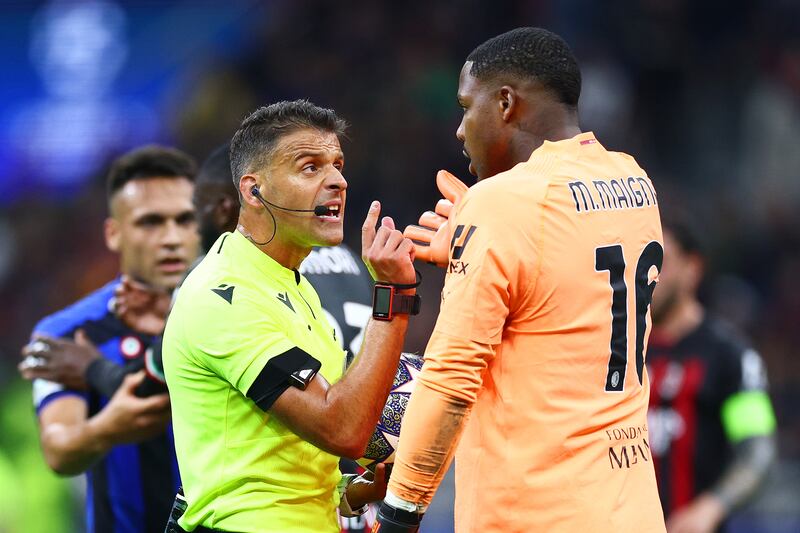 Referee Jesus Gil Manzano is confronted by AC Milan keeper Mike Maignan after he awarded a penalty to Inter for a foul on Lautaro Martinez, which he later overturned after a VAR review. Getty 