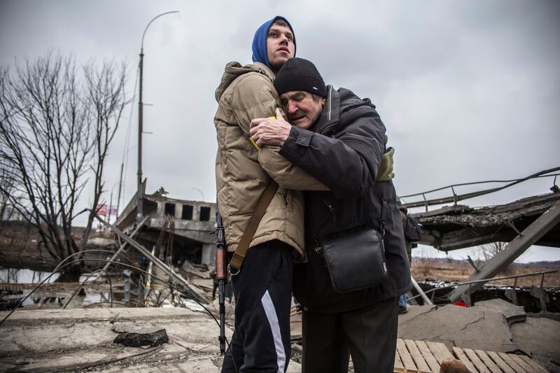 A Ukrainian serviceman comforts a resident who is leaving his home after Russian artillery shelling in Irpin, on the outskirts of Kyiv. AP