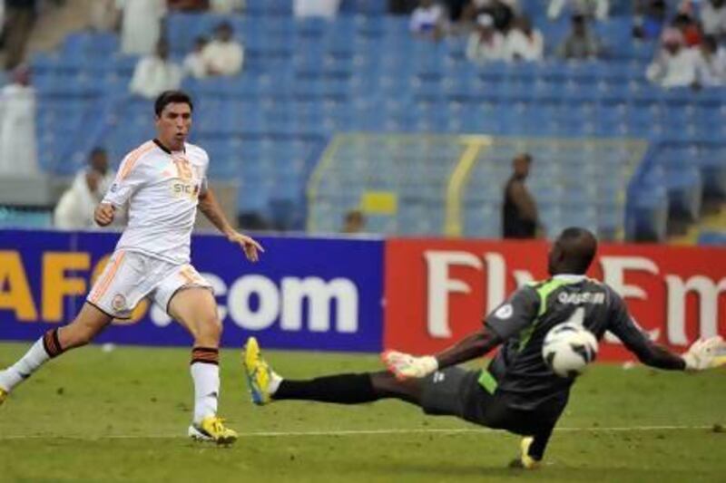 Sebastian Tagliabue, left, scores for Saudi Arabia’s Al Shabab against Qatar’s Al Gharafa goalkeeper Qasem Burhan last month.