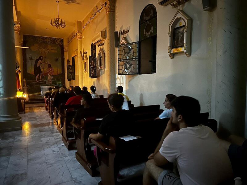 A candlelit prayer in the church that holds mass twice a day despite the incessant bombing