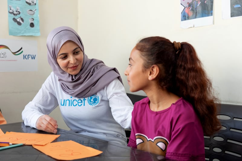 Muzoon Almellehan with 11-year-old Raghad during an English learning support class.
