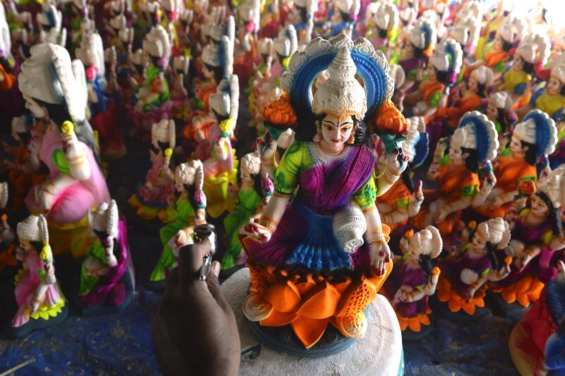 An artisan paints a statue of Lakshmi on the outskirts of Hyderabad. AFP