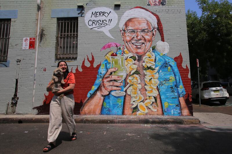 A person stands in front of a satirical mural by artist Scott Marsh depicting Australian Prime Minister Scott Morrison, on a wall in Sydney, Australia.  EPA