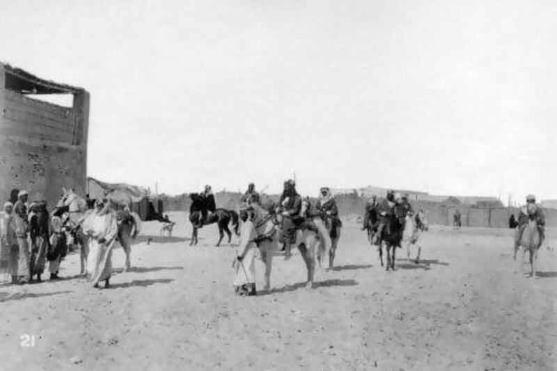 The original caption for this photograph, circa 1910, reads: 'Pirate Coast: The Sheikh of Abu Thabi and his stalwart sons, Sheikh has just dismounted, sons on horseback'.