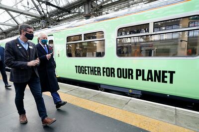 Britain's then-Prince Charles walks alongside a hydrogen-powered train with Martin Frobisher, Network Rail group engineering director at Glasgow Central Station, on the sidelines of Cop26, in Glasgow, Scotland, on November 5, 2021. AP