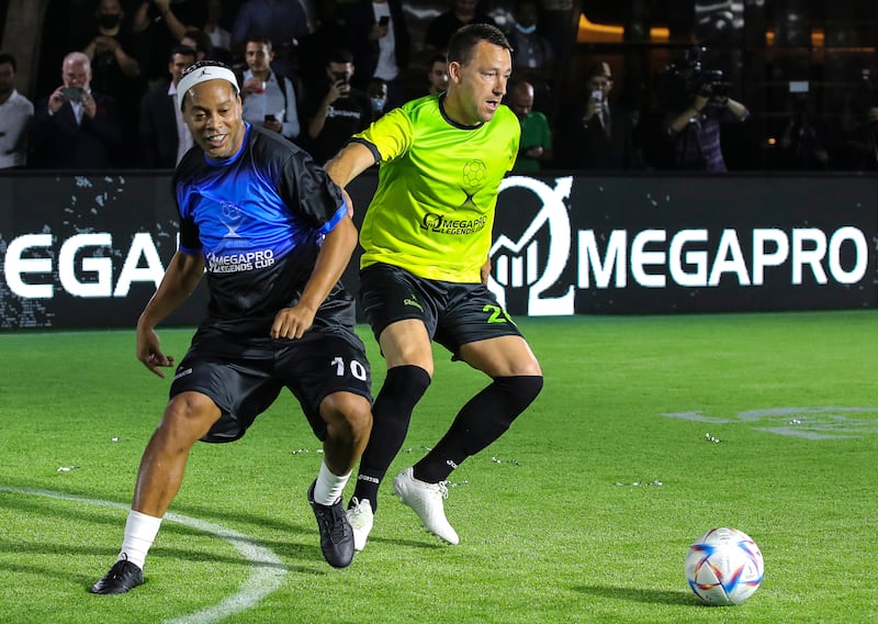 Former Brazilian soccer player Ronaldinho (L) and former English player John Terry (R) in action during the OmegaPro Legends Cup friendly exhibition soccer match at Armani Arab hotel near the Burj Khalifa, the world's tallest building, in the Gulf emirate of Dubai, United Arab Emirates, 12 May 2022.   EPA / ALI HAIDER